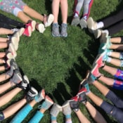 A circle of girl's feet form a heart